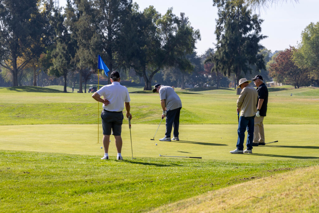 A group of gentleman putting on a golf course.