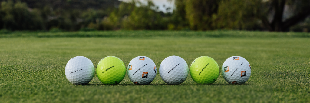 A photo with TaylorMade Tp5, Tp5x, and Tp5x Pix golf balls lying on grass.
