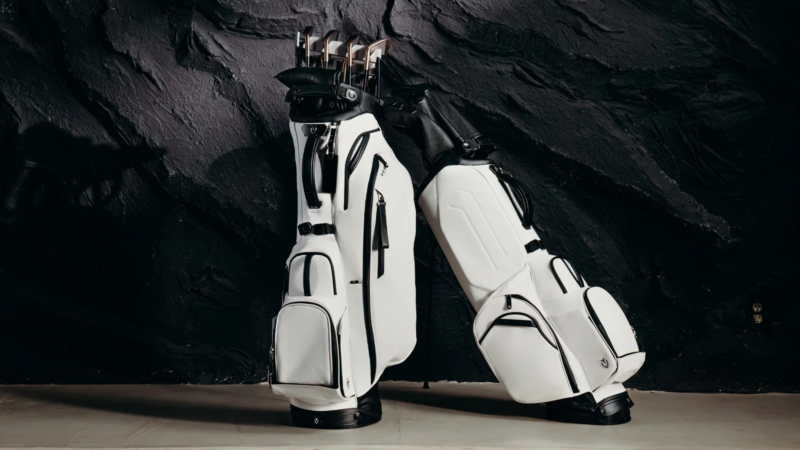 Two white and black golf bags leaning on each other